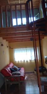 sala de estar con cama elevada y sofá en El Jardin de Sauce, en Monte Hermoso