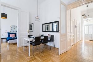 a dining room with a table and black chairs at Black & white apartment Budapest in Budapest