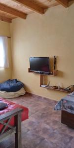 Una sala de estar con un televisor de pantalla plana en la pared. en El Jardin de Sauce, en Monte Hermoso