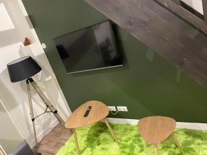 a room with two chairs and a tv on a green wall at La pause zen in Tulle