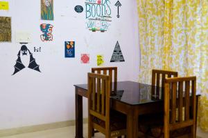 a dining room with a table and two chairs at Verge Hostel in Varkala