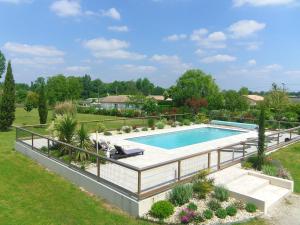 una imagen de una piscina en un patio en "Le gite du Petit Guilhem" Près Bordeaux Maison classée 4étoiles Meublé Tourisme piscine parc étang, en Anglade