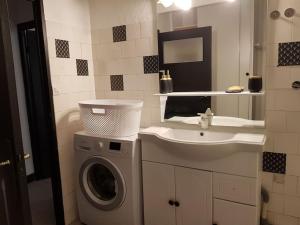 een badkamer met een wasmachine en een wastafel bij La bellevue Nimoise in Nîmes