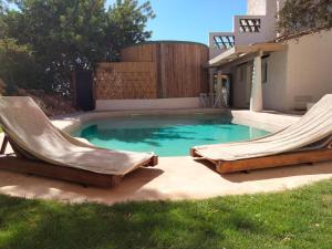 una piscina con 2 tumbonas en un patio en Apartamento Caolin Rocabella en El Chorro