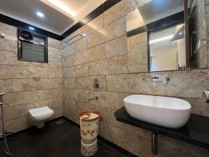 a bathroom with a sink and a toilet at Hotel Aryadeep in Phardāpur