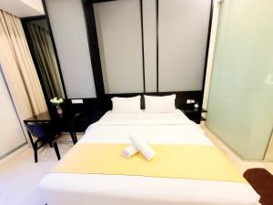 um quarto de hotel com duas camas com uma toalha na cama em Tropicana Residence Klcc @ Roof Top Swimming Pool em Kuala Lumpur