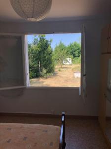 a bedroom with a window with a view of a field at Maison à 500 mètres de la plage in Saint-Trojan-les-Bains