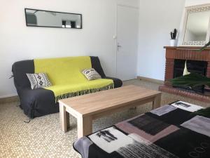 a living room with a yellow couch and a coffee table at Maison à 500 mètres de la plage in Saint-Trojan-les-Bains