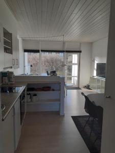 a kitchen with a counter and a table in a room at Henne Strand. Ferielejlighed 200m fra Vesterhavet in Henne Strand