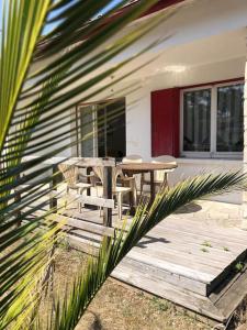 una terraza de madera con mesa y sillas en una casa en Maison à 500 mètres de la plage, en Saint-Trojan-les-Bains