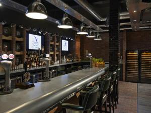 a bar with chairs and a counter with alcohol at Village Hotel Edinburgh in Edinburgh