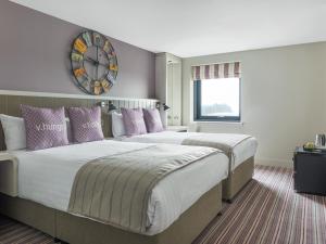a bedroom with a large bed and a large window at Village Hotel Edinburgh in Edinburgh
