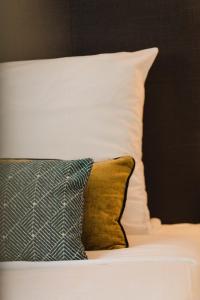 a bed with two pillows and a white pillow at Les Caravelles - Trois Pièces - Deauville Centre in Deauville