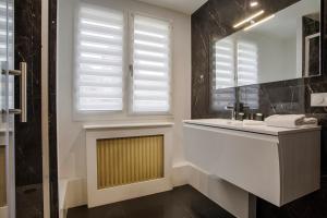 a bathroom with a sink and a mirror and a window at Les Caravelles - Trois Pièces - Deauville Centre in Deauville