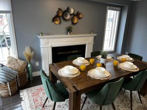 a dining room table with chairs and a fireplace at Chic, Spacious Home You'll Love in Markham