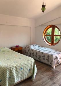 two beds in a room with a window at Heredot's house in Finike