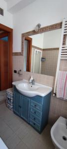 La salle de bains est pourvue d'un lavabo et d'un miroir. dans l'établissement CasAmare, à Torvaianica