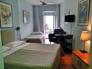アッシジにあるイ コロリ ディ アッシジのベッド2台と窓が備わるホテルルームです。