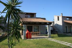una casa con una mesa y una cometa roja en Villa Cala Sinzias en Castiadas