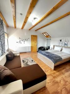 sypialnia z łóżkiem i kanapą w obiekcie Vila SOFIA w mieście Haţeg