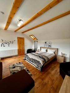 1 dormitorio con 1 cama grande y suelo de madera en Vila SOFIA en Haţeg