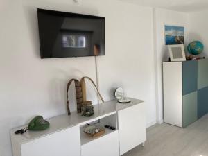 a white shelf with a television on a wall at Casa Bianca in Fehmarn