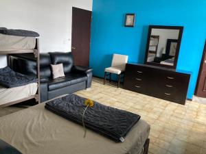 a bedroom with a bed and a mirror and a chair at Casa de Huéspedes, Casa Sol, Hospedaje para Grupos in Aguascalientes