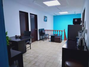 a room with a room with a refrigerator and chairs at Casa de Huéspedes, Casa Sol, Hospedaje para Grupos in Aguascalientes