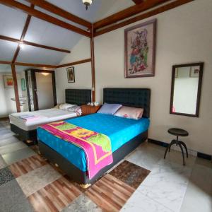 a bedroom with two beds and a stool in it at Omah Singo Stay and Resto in Bantul