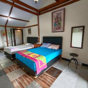 Postel nebo postele na pokoji v ubytování Omah Singo Stay & Resto Yogyakarta + 37 fotografií
