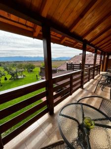 eine Veranda mit einem Tisch und Blick auf ein Feld in der Unterkunft Vila SOFIA in Haţeg