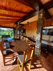 ein Esszimmer mit einem Holztisch und Stühlen in der Unterkunft Vila SOFIA in Haţeg