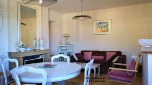sala de estar con sofá, mesa y sillas en Charme Le Cadran Solaire classé 4*, en Sancey-le-Long