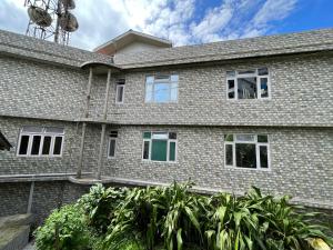 a large brick house with windows at The Sherpa's Abode in Gangtok