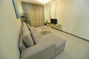 un soggiorno con divano e tavolo di Noble Rose Apartment a Kuwait