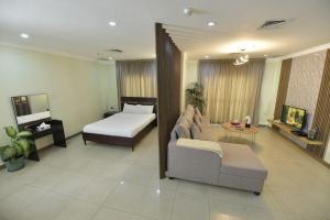 - un salon avec un lit et un canapé dans l'établissement Noble Rose Apartment, à Koweït