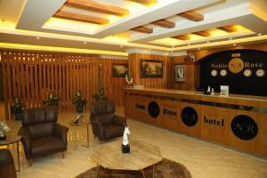 a hotel lobby with chairs and a reception desk at Noble Rose Apartment in Kuwait