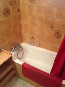 a bathroom with a bath tub with a red towel at Maeva in Saint-Laurent-du-Var