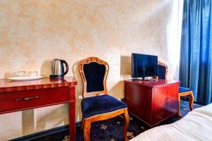 基輔的住宿－Hotel Kiev Lomakin，一间卧室配有书桌、电视和椅子