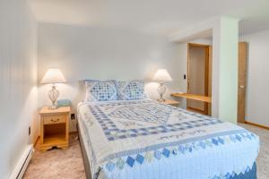a bedroom with a blue and white bed and two lamps at Bamboo House - Meredith Lodging in Nehalem