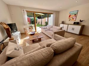 a living room with a couch and a tv at Maison « Embruns de mer » à 800 m de la mer in La Pironnière