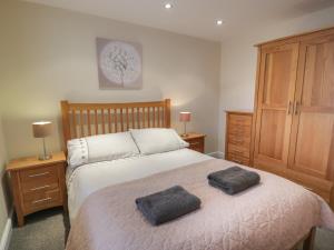 a bedroom with a bed with two pillows on it at Whistle Stop Apartment in Porthmadog