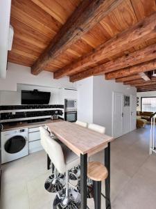 cocina con techo de madera y mesa de madera en Beau T3 au cœur du centre ville, en Narbona