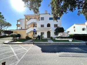 un gran edificio blanco con aparcamiento en Quarteira Classic 1 With Pool by Homing, en Quarteira