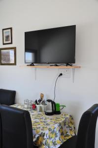 a dining room table with a tv on the wall at Vastu Dead Sea apartment in Arad