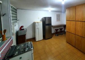 uma cozinha com um fogão, um frigorífico e uma mesa em Hostel Airport Rooms em São Paulo