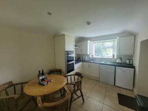 a kitchen with a wooden table and a table and chairs at Stoneyford Village in Stonyford