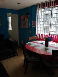 un comedor con mesa y una habitación con paredes azules en Departamento de huéspedes Grijalva, en Ciudad de México