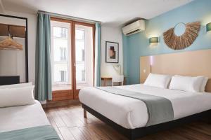 パリにあるHôtel Kabanel by Happycultureのベッドが2つと窓があるホテルの部屋