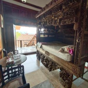 a bedroom with a bed and a table and a mirror at Omah Singo Stay and Resto in Bantul